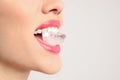 Young woman holding ice cube in mouth on light background, closeup Royalty Free Stock Photo