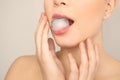 Young woman holding ice cube in mouth on light background Royalty Free Stock Photo