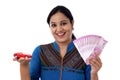 Young woman holding indian currency and toy car against white Royalty Free Stock Photo