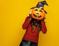 Young woman holding jack-o-lantern pumpkin in front of face Royalty Free Stock Photo