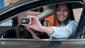 Young woman holding keys to new car auto and smiling at camera. Royalty Free Stock Photo