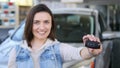 Young woman holding keys to new car auto and smiling at camera Royalty Free Stock Photo