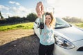 Young woman holding keys to new car and smiling at camera Royalty Free Stock Photo