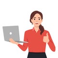 Young woman holding laptop computer and thumbs up gesture. Trendy girl using gadget and showing good or like sign