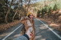 Young woman holding man`s hand and leading him on nature.Couple in love.