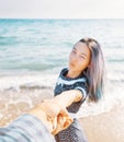 Woman holding man`s hand and leading him to sea. Royalty Free Stock Photo