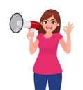 Young woman holding a megaphone/loud speaker and gesturing cool, okay/OK sign. Girl making announcement with megaphone. Royalty Free Stock Photo