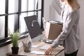 Young woman holding moving box with office stuff indoors Royalty Free Stock Photo