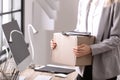 Young woman holding moving box with office stuff indoors Royalty Free Stock Photo