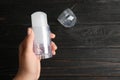 Young woman holding natural crystal alum deodorant over black wooden table. Space for text Royalty Free Stock Photo