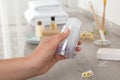 Young woman holding crystal alum deodorant at wooden table, closeup