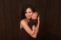 Young woman holding a newborn baby in her arms on the white background. Newborn photosession. Family portrait. Mother is kissing h Royalty Free Stock Photo