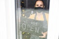 Young woman holding open sign in cafe Royalty Free Stock Photo