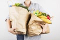 Young woman holding papers shopping bags on gray background Royalty Free Stock Photo