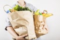 Young woman holding papers shopping bags on gray background Royalty Free Stock Photo