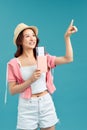 Young woman holding passport, credit card. Smiling girl traveler on blue background Royalty Free Stock Photo