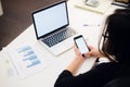 Young woman holding a phone. Workplace near the window with laptop. Close up Royalty Free Stock Photo