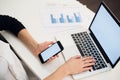 Young woman holding a phone. Workplace near the window with laptop. Close up Royalty Free Stock Photo