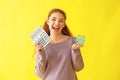 Young woman holding piggy bank and calculator on color background. Money savings concept Royalty Free Stock Photo