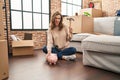 Young woman holding piggy bank and hammer moving to a new home clueless and confused expression Royalty Free Stock Photo