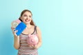 Young woman holding piggy bank and wallet with dollar banknotes on color background. Money savings concept Royalty Free Stock Photo