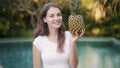 Woman holding pineapple fruit in hands and showing thumbs up sign, that good