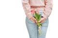 Young woman holding of pink tulips behind her back on a white background. Royalty Free Stock Photo