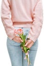 Young woman holding of pink tulips behind her back on a white background. Royalty Free Stock Photo