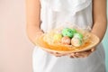 Young woman holding plate with painted Easter eggs on color background, closeup Royalty Free Stock Photo