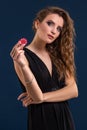 Young woman holding playing chips against dark background. Studio shot Royalty Free Stock Photo