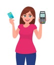 Young woman holding pos payment terminal and card. Girl showing credit/debit cards swiping machine. Wireless modern bank payment. Royalty Free Stock Photo