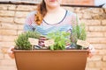 Young woman holding pot of aromatic herbs
