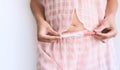 Woman holding pregnancy test in hands near her belly