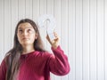 Young woman holding a question mark sign with confused and doubt expression. Royalty Free Stock Photo