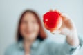 Portrait of a beautiful young woman holding a red apple against a gray wall background. Healthy food diet. Apple vitamin Royalty Free Stock Photo