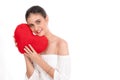 Young woman holding red cushion heart shape smiling isolated in white background and looking at camera with Royalty Free Stock Photo