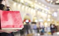 Young woman holding red shopping bag at department store Royalty Free Stock Photo