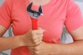 A young woman holding a red wrench. A tool to repair plumbing yourself. Wrench close-up in women`s hands