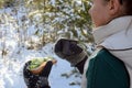 Young woman holding sandwitch and coffee mug in winter forest. Royalty Free Stock Photo