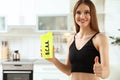 Young woman holding shaker with amino acids BCAA drink in kitchen