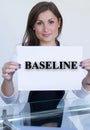 Young woman holding a sheet of paper with the text baseline Royalty Free Stock Photo