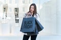 Young woman holding shopping bag at shopping center. Black Friday, consumerism, sale Royalty Free Stock Photo