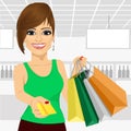 Young woman holding shopping bags and giving a credit card Royalty Free Stock Photo