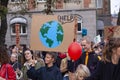 Young woman holding a sign reading with a cartoon drawing of the Earth saying HELP Royalty Free Stock Photo