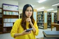 Young woman holding smartphone and making shush gesture as sign of silence, secrecy, secret, keep quiet sign