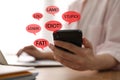 Young woman holding smartphone at table, closeup. Cyber bullying