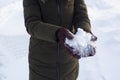 Young woman holding snow in her hands in mittens, winter, fun, joy, sports, recreation, children