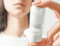 Woman holding spray inhaler against asthma attack.