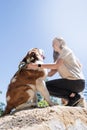 young woman holding St.Bernard dog hiking at the mountains