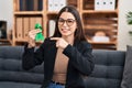 Young woman holding support green ribbon smiling happy pointing with hand and finger